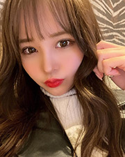 長い茶髪の女性がこちらを見ている。口紅が真っ赤。白いタートルネックの上に黒い革ジャケットを着ている。至近距離で撮影された写真である。