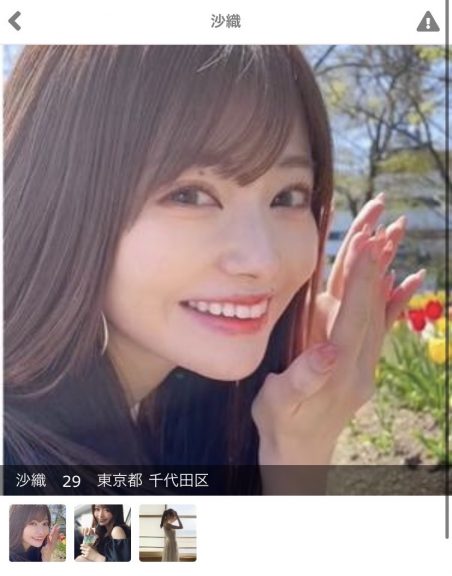 茶髪のロングヘアの女性が楽しそうにこちらを見ている。後ろにはチューリップ畑が見える。
