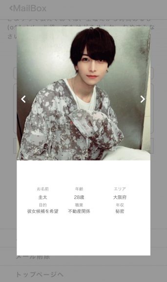 迷彩柄のロングシャツを着てこちらをみている男性。
