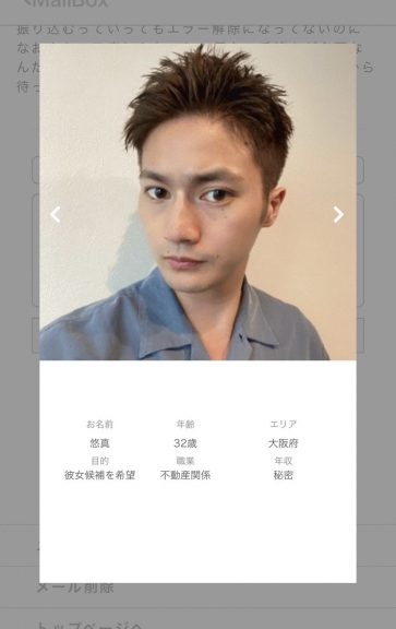 薄い群青色のシャツを羽織っている短髪の男性。目力が特徴的だ。